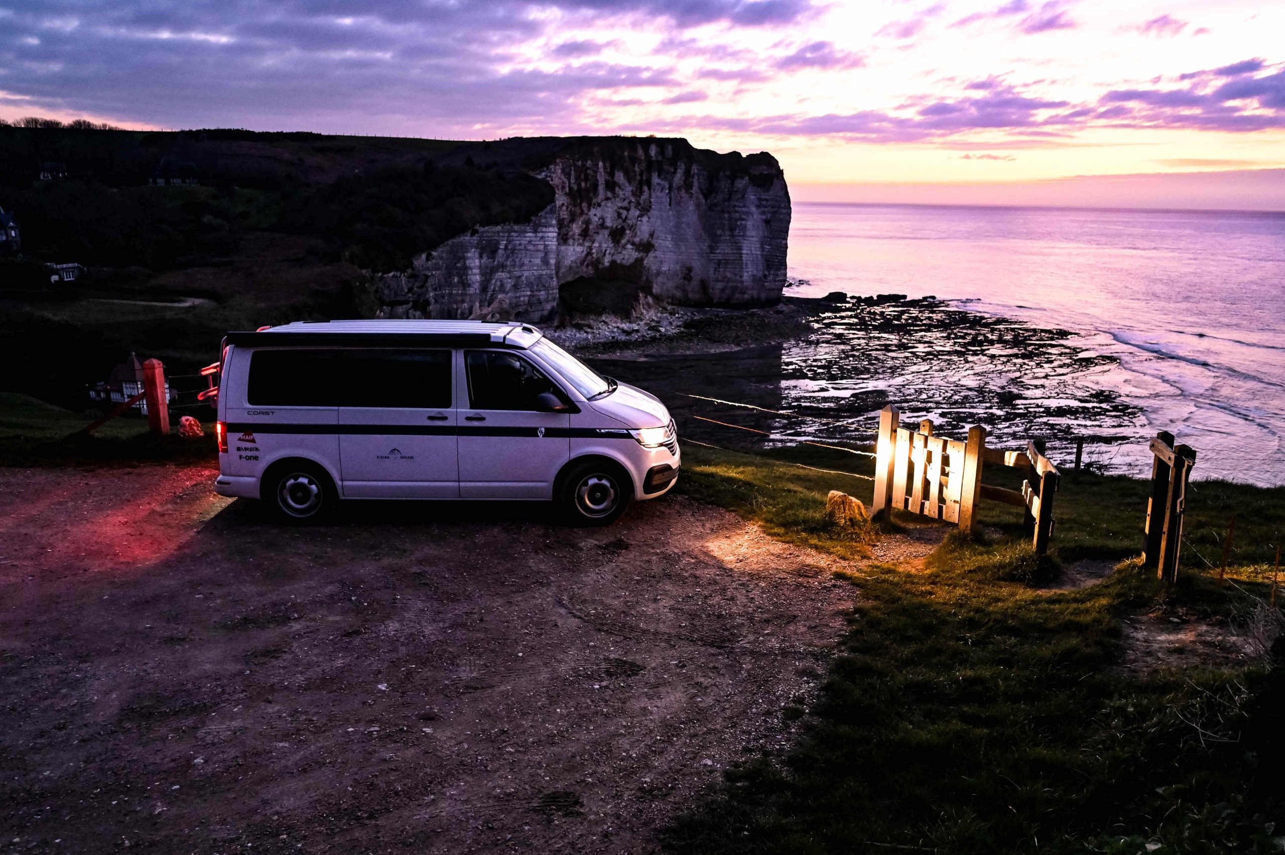 van-crepuscule-falaise-bretagne-mer|falaise-bretagne-reveil-matin-couette-van|vue sur le mont saint michel|van nature bretagne sauvage|van parking falaise plage bretagne nature|van-california-gris-buissons-plage-crepuscule