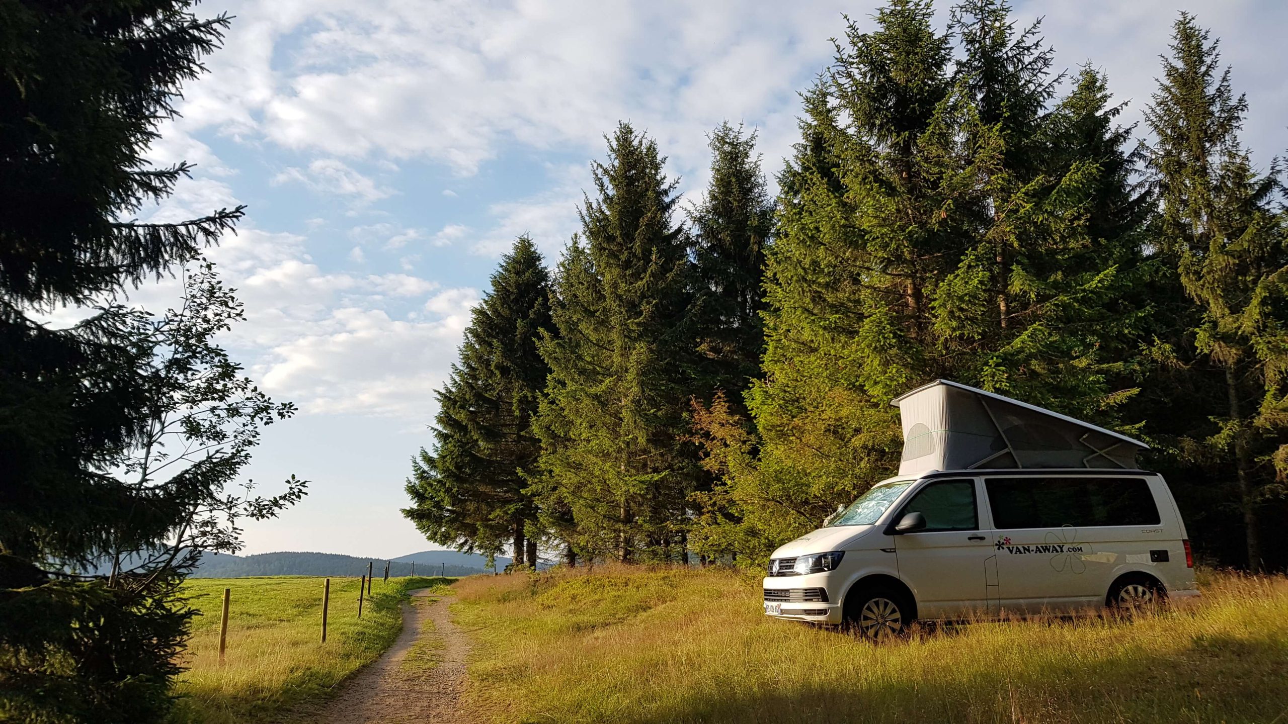van tente toit clairiere arbres soleil|van away falaise ocean buissons|femme eaux propres usees van amenage|van nuit nature etoiles|route pont van soleil montagne|van away panneaux solaires|enfant hamac nature van amenage